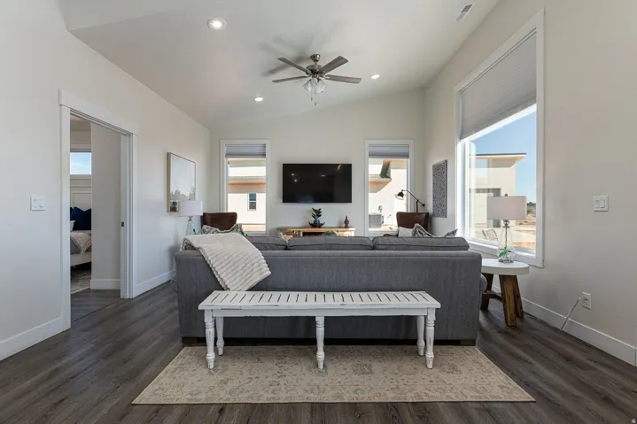 Living room featuring ceiling fan, dark wood finished floors, healthy amount of natural light, lofted ceiling, and recessed lighting