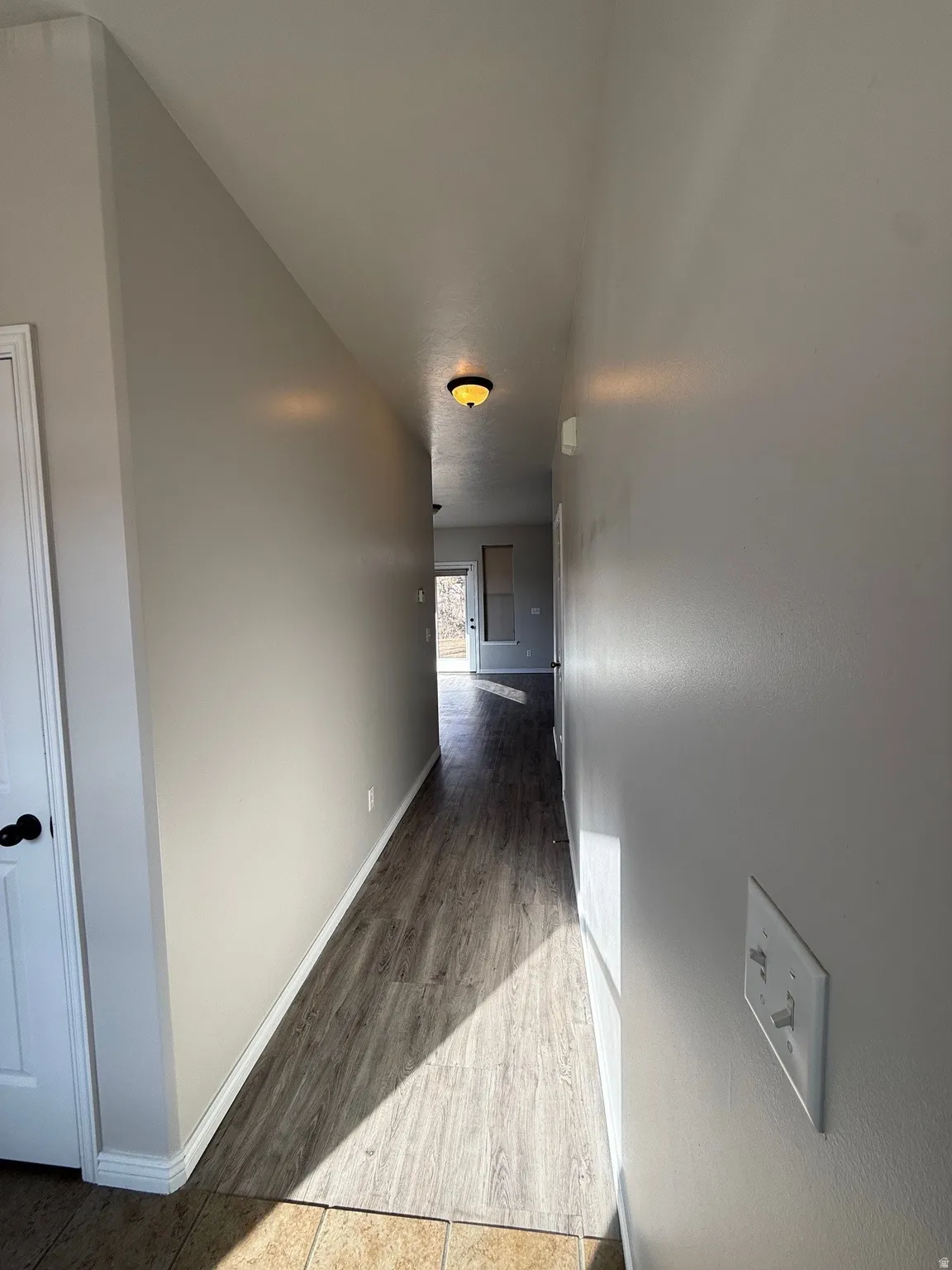 Hallway featuring light wood-style floors and baseboards