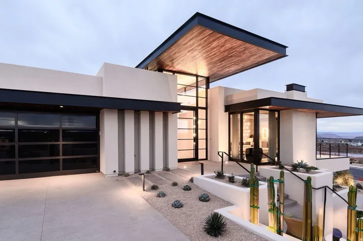 View of exterior entry with concrete driveway, stucco siding, and an attached garage