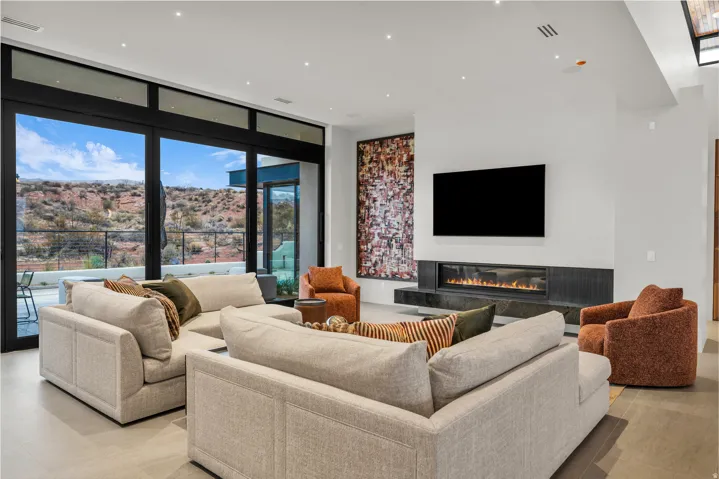 Living room with floor to ceiling windows, a premium fireplace, and recessed lighting