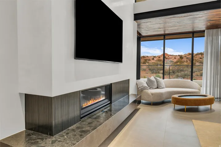 Living room featuring a glass covered fireplace and expansive windows