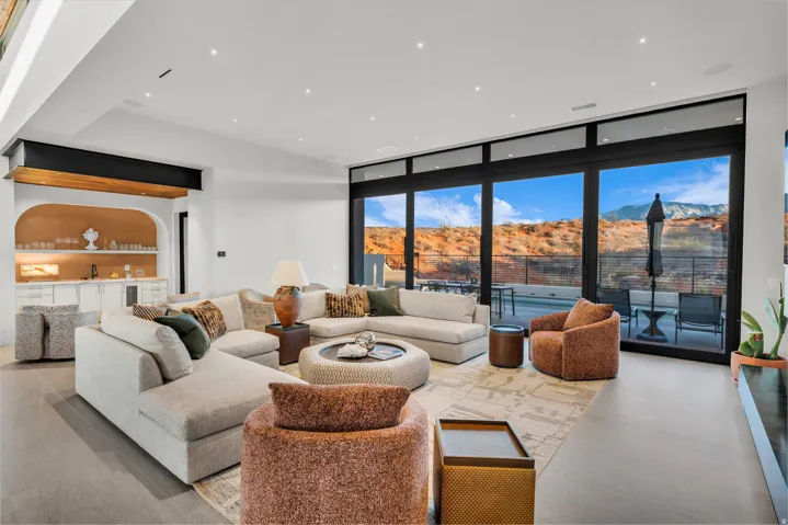 Living room with floor to ceiling windows, a mountain view, bar with sink, and recessed lighting