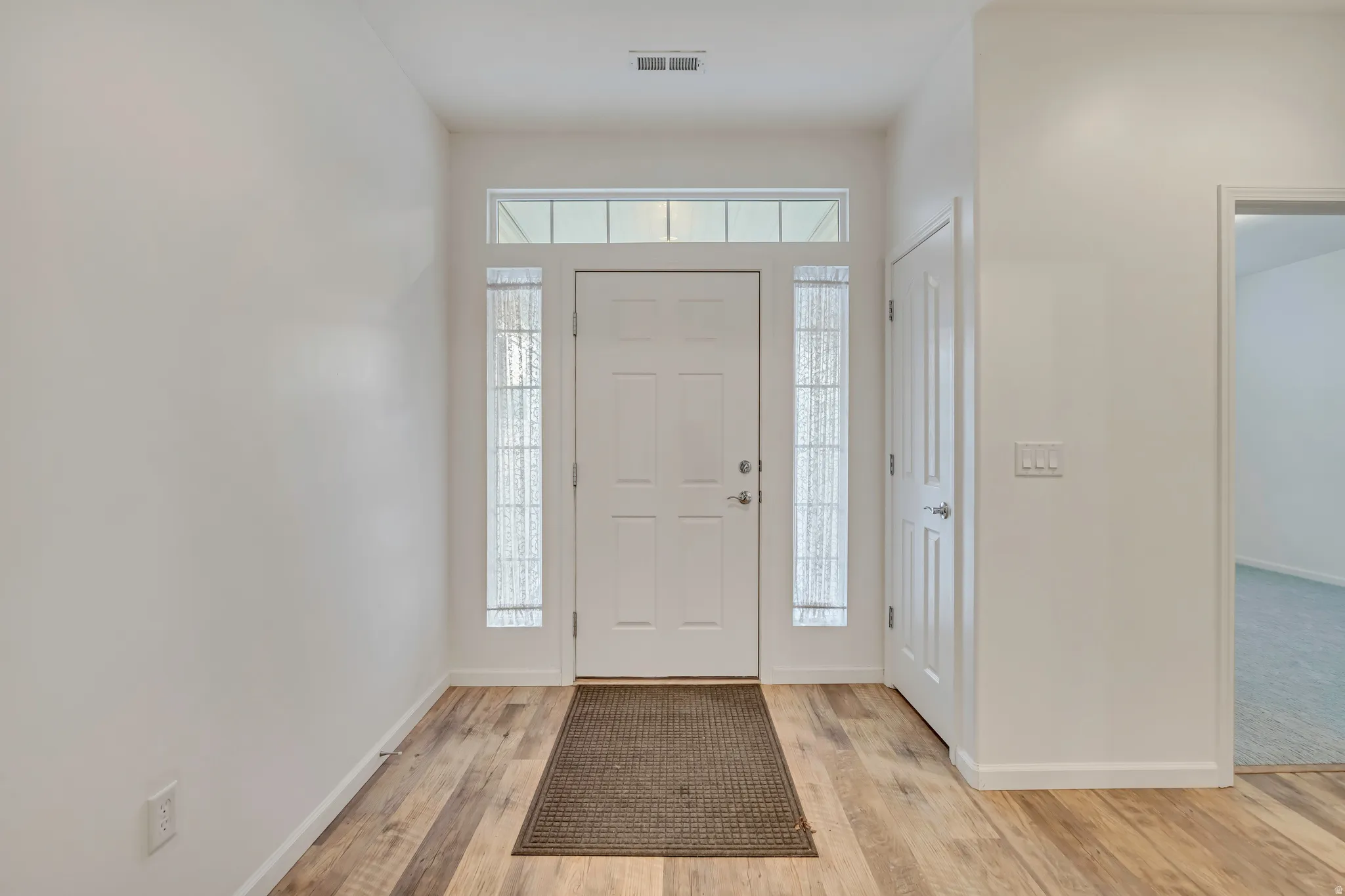 Foyer with light wood-style floors