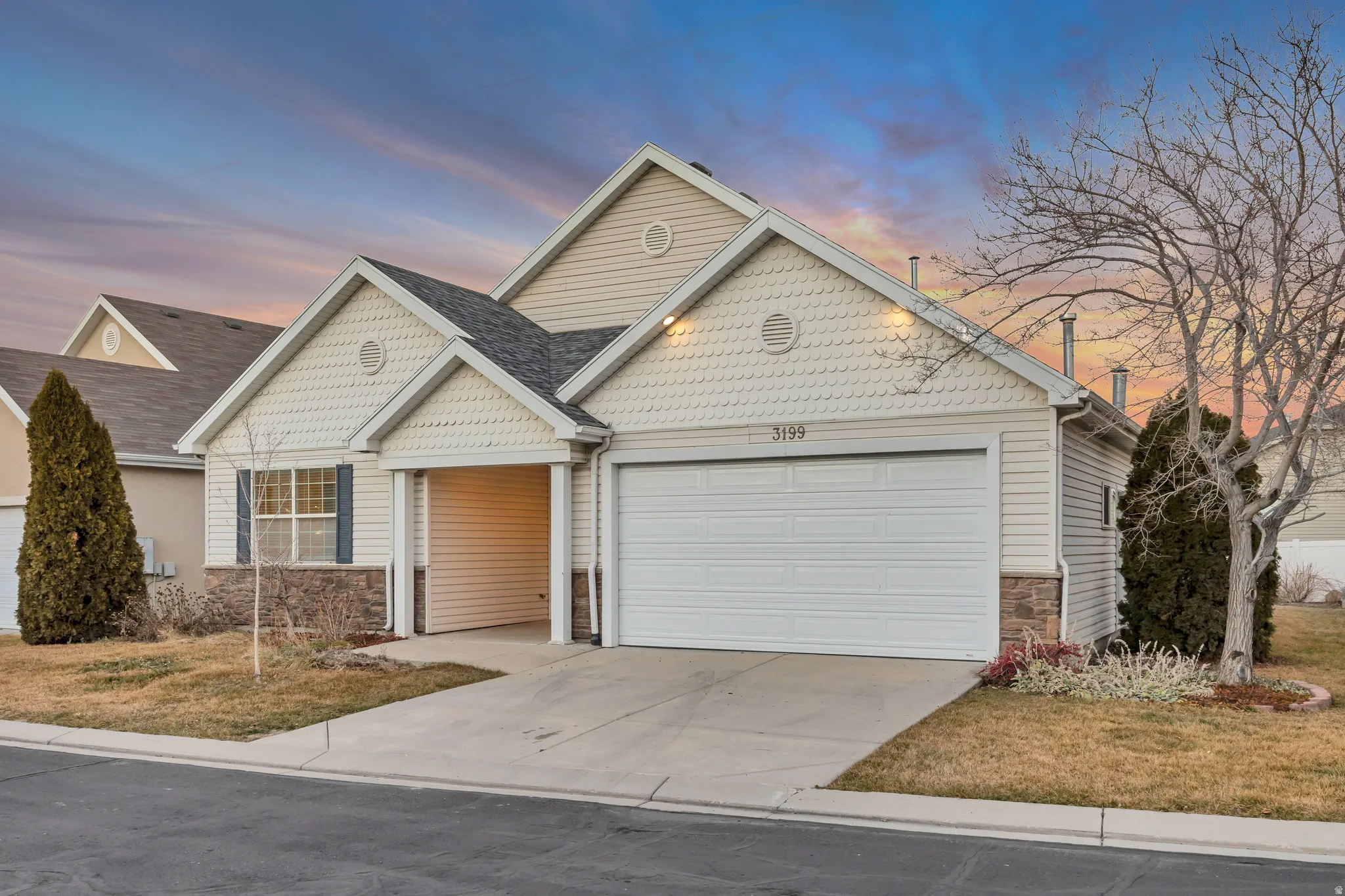 View of front of property with stone siding, a garage, and driveway