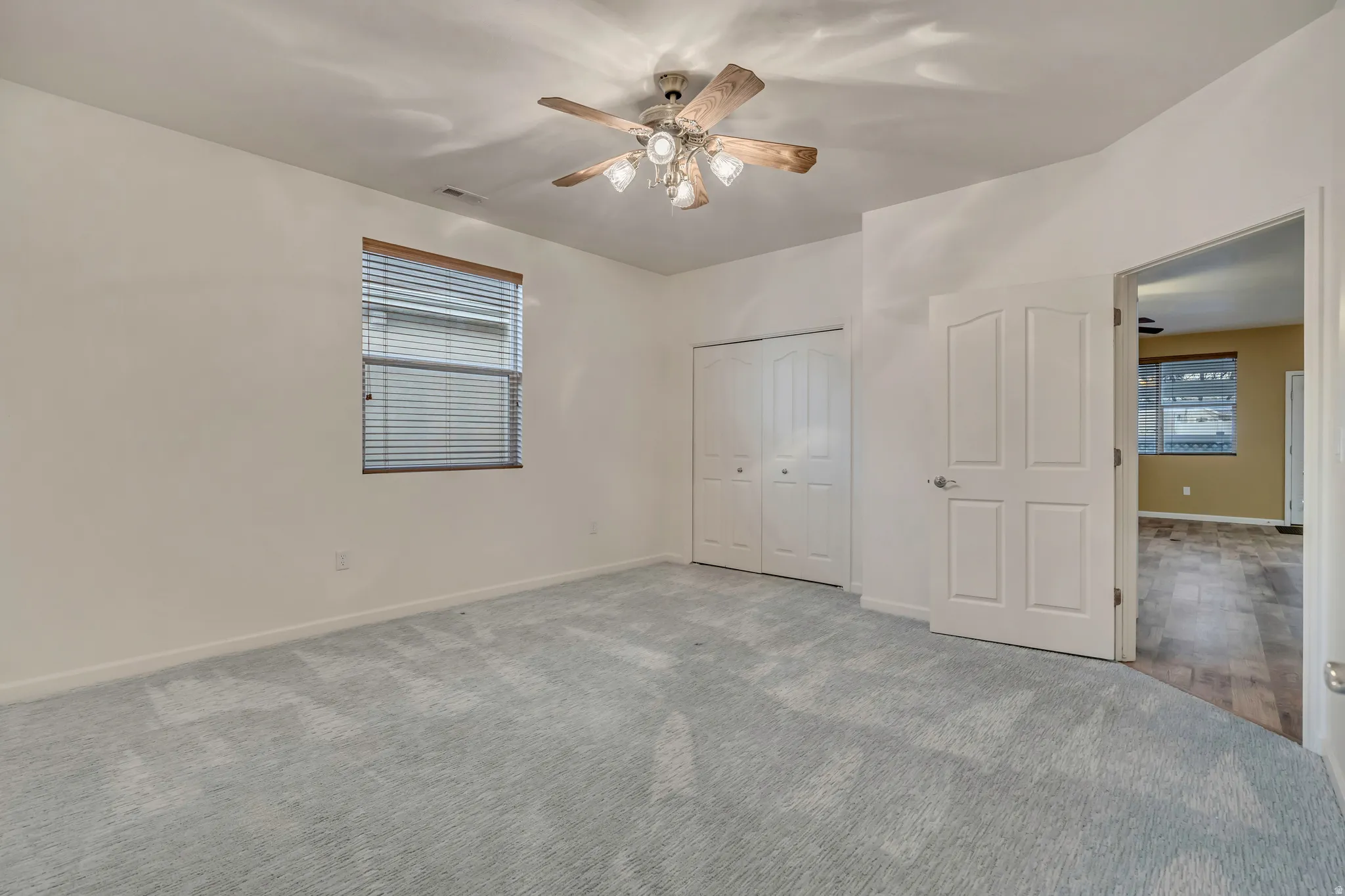 Unfurnished bedroom with a closet, ceiling fan, and carpet floors
