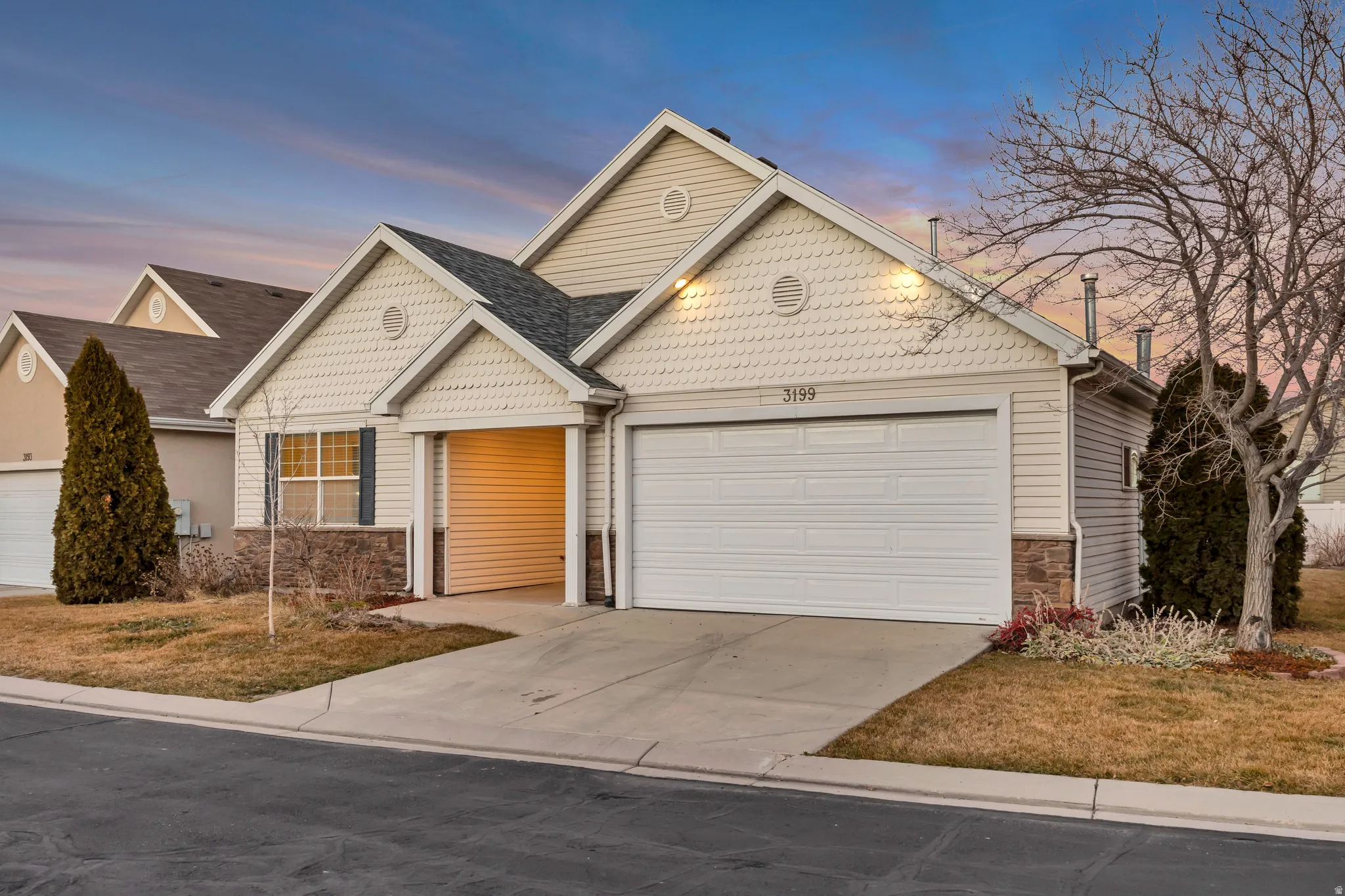View of front of house featuring stone siding, concrete driveway, and a garage