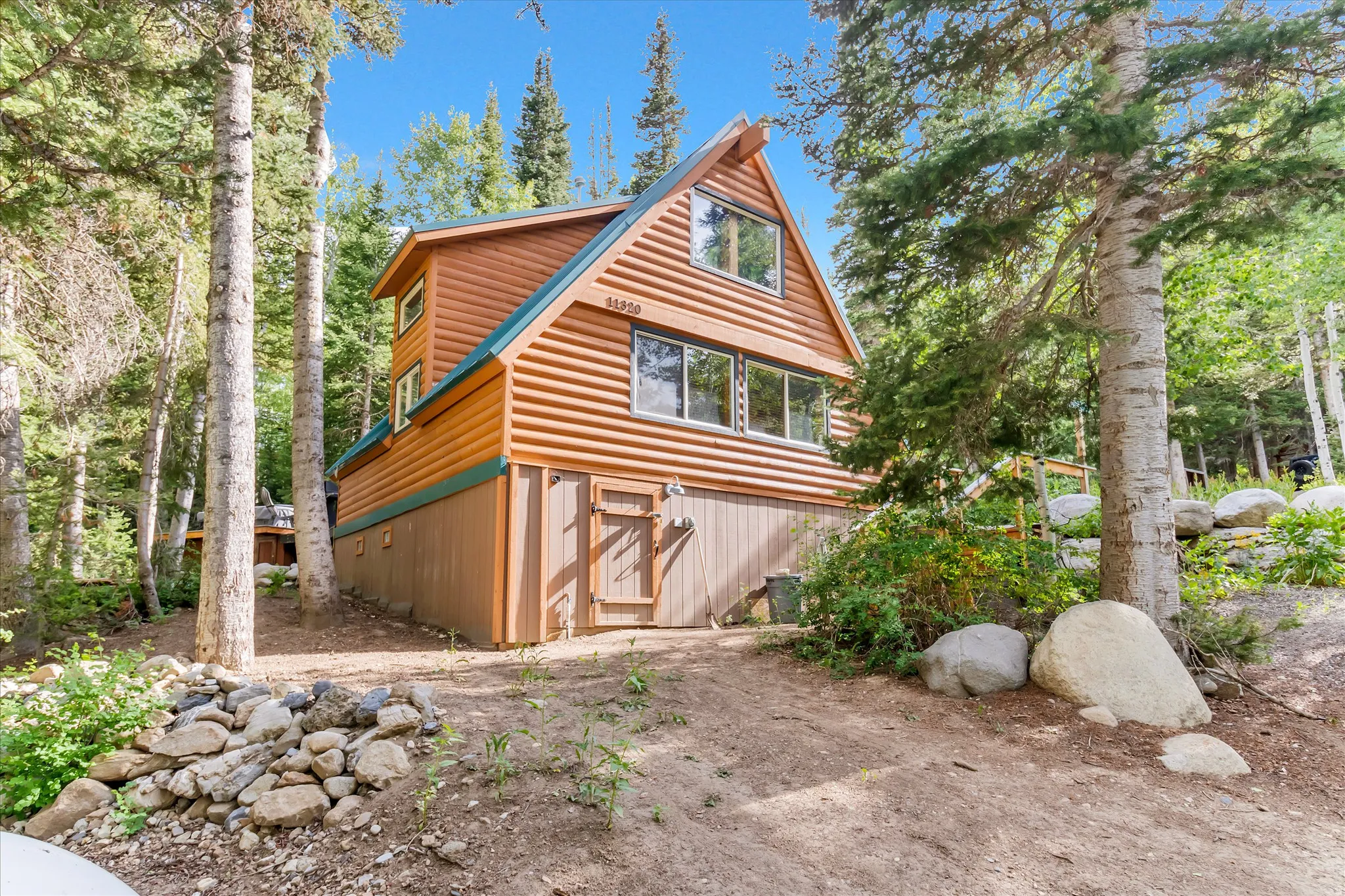 Log-sided cabin featuring a prominent A-frame roofline and multiple windows