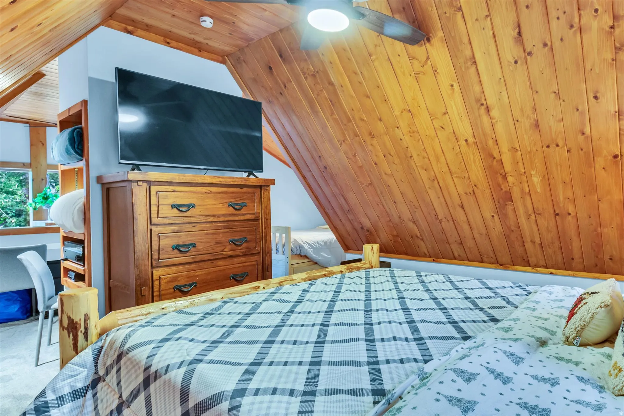 Sloped wood-finish ceiling with a ceiling fan