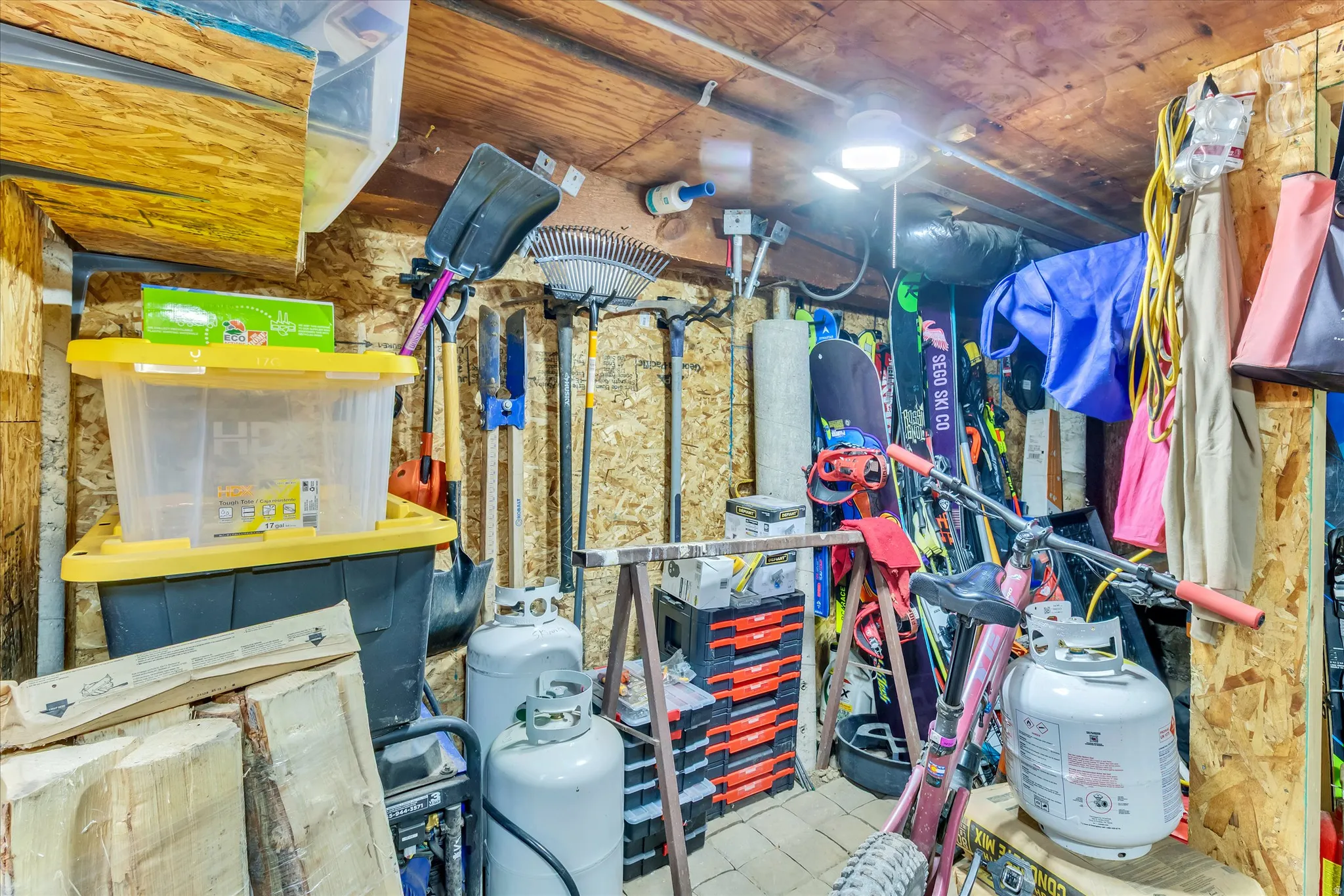 Utility area with exposed wood-finish walls and ceiling, featuring a mounted ceiling light fixture