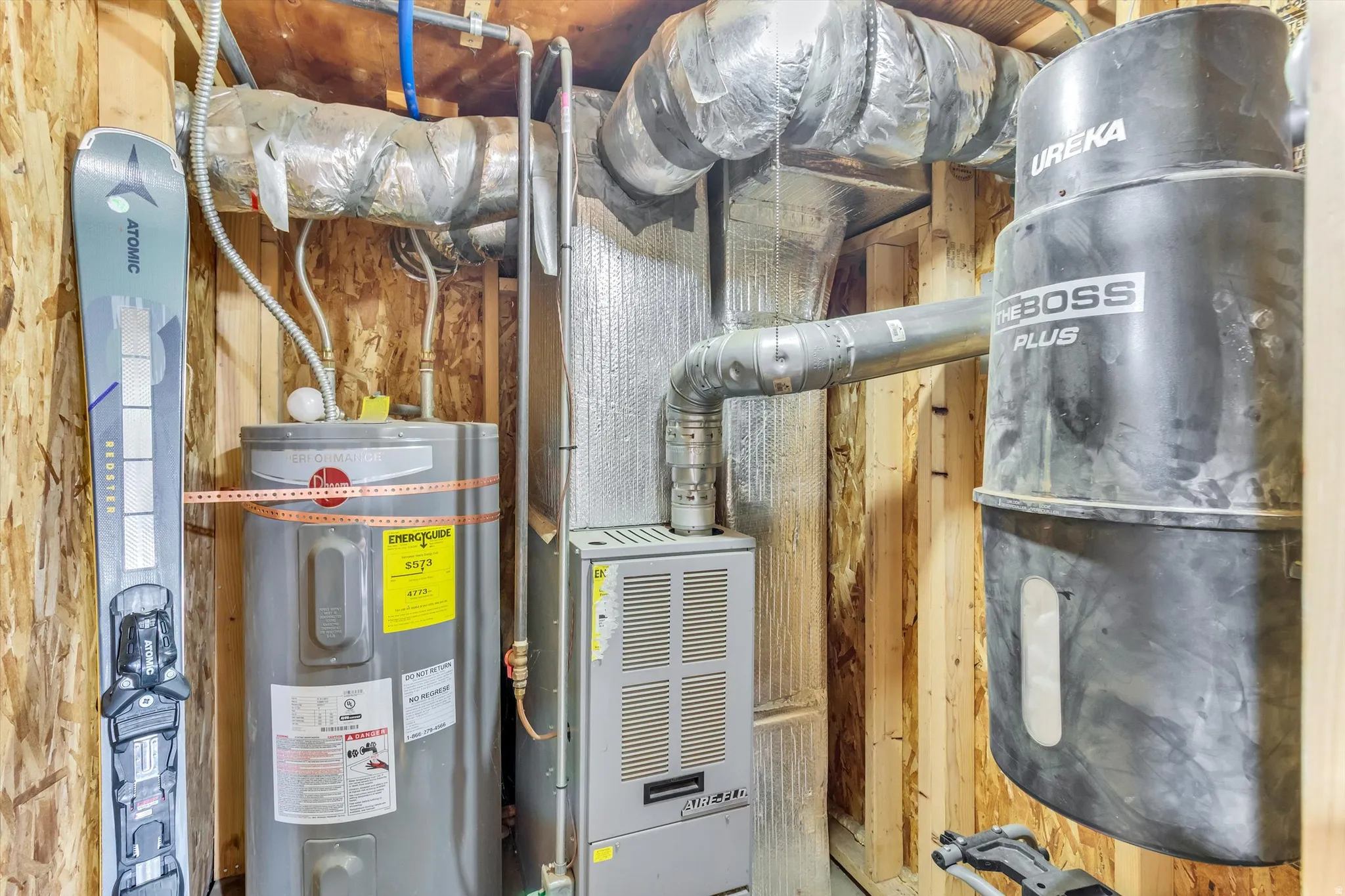 Utility area featuring a water heater, furnace, and central vacuum system with exposed wood framing
