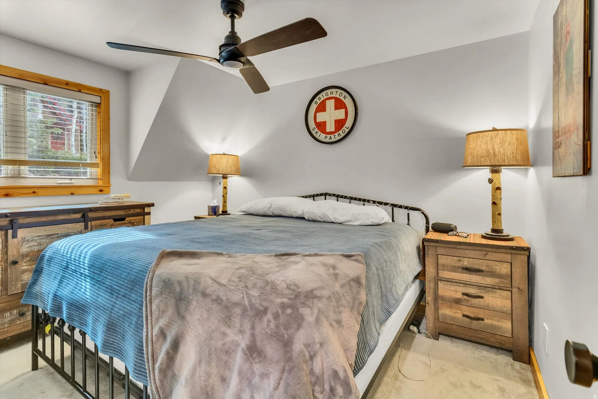 Bedroom featuring a ceiling fan, window with wood trim and blinds, light-colored walls, and concrete flooring