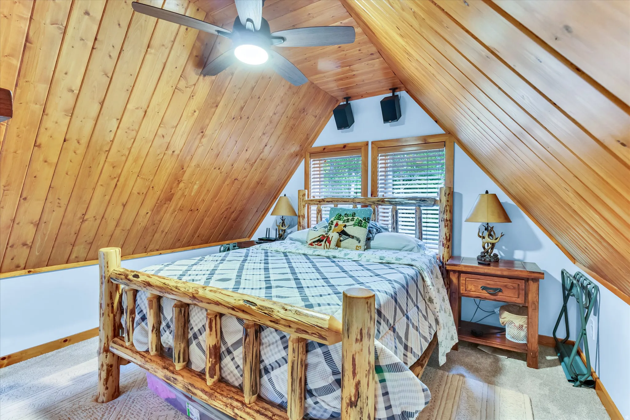 Sloped wood-paneled ceilings with an integrated ceiling fan