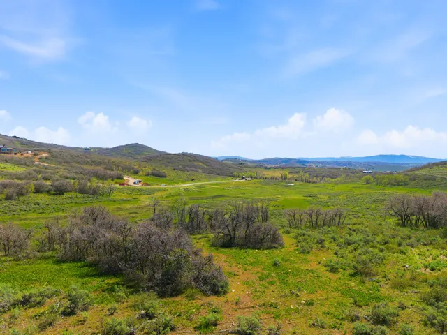 Expansive land parcel featuring rolling hills and distant mountainous terrain