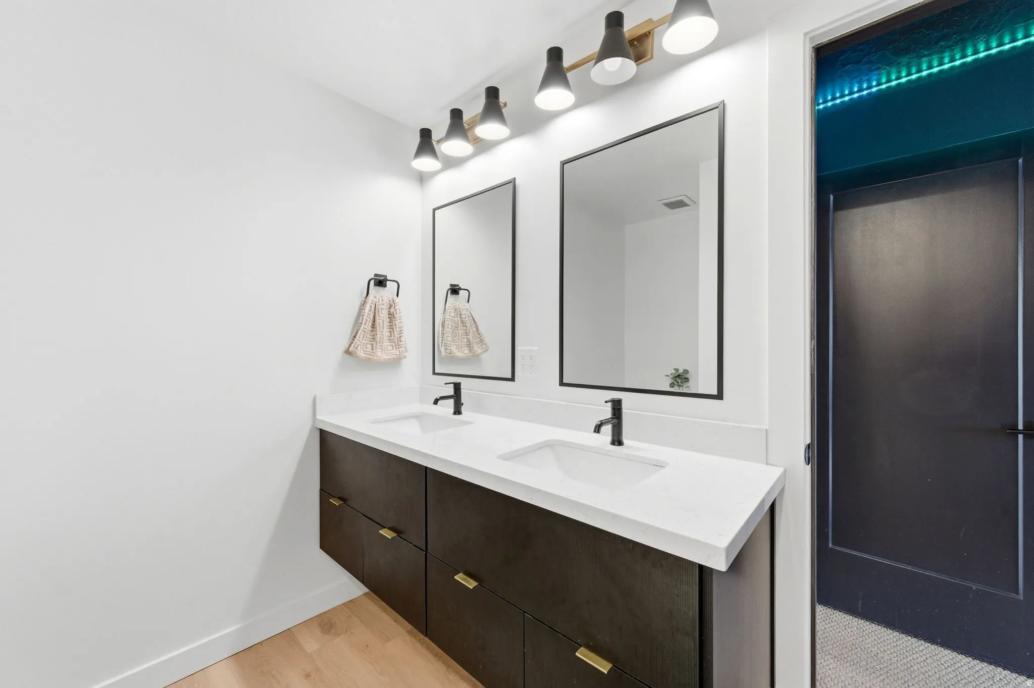 Full bathroom featuring double vanity and light wood finished floors