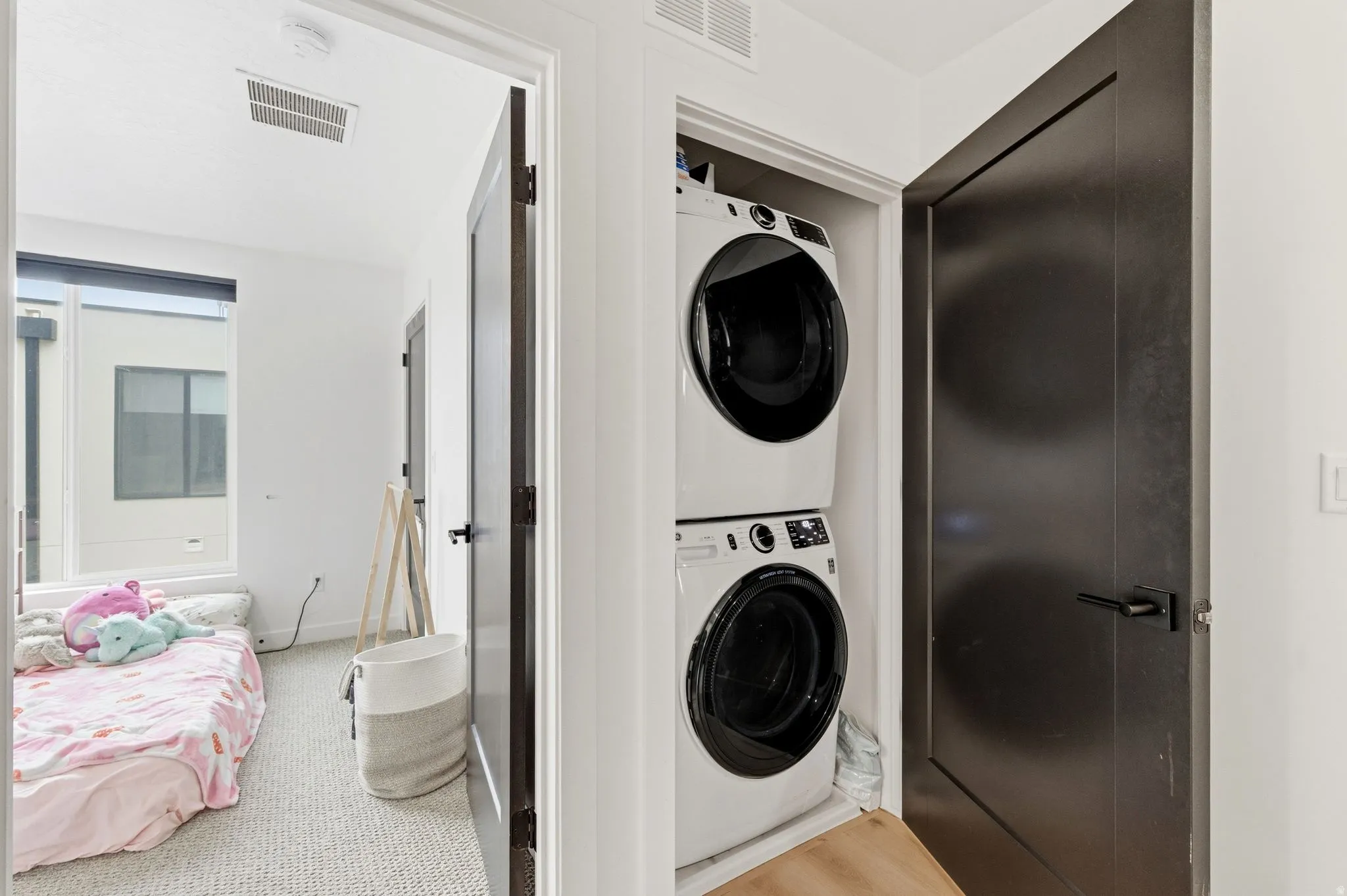 Laundry area with stacked washer and dryer