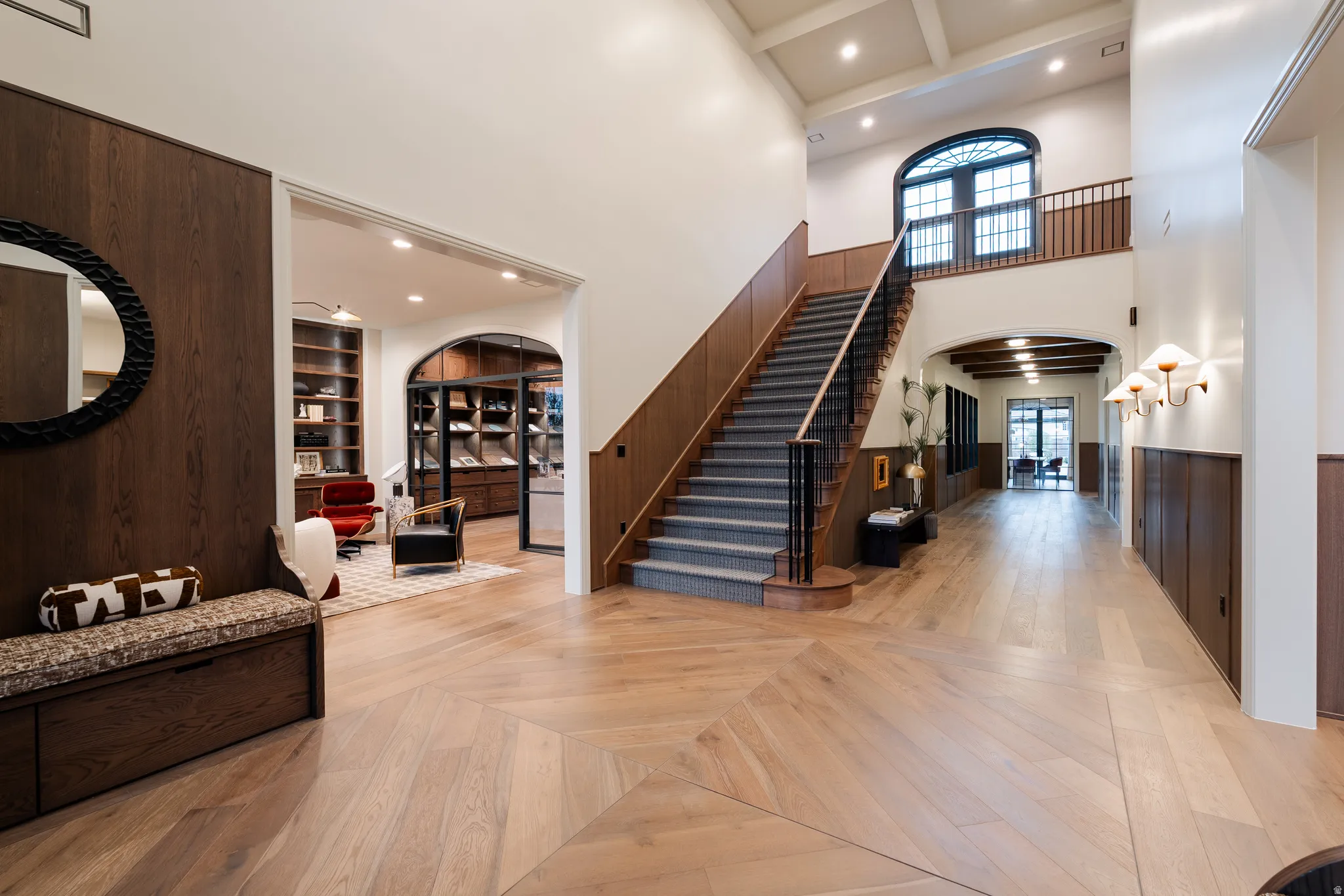 Foyer with parquet floors, arched walkways, recessed lighting, wooden walls, and a high ceiling
