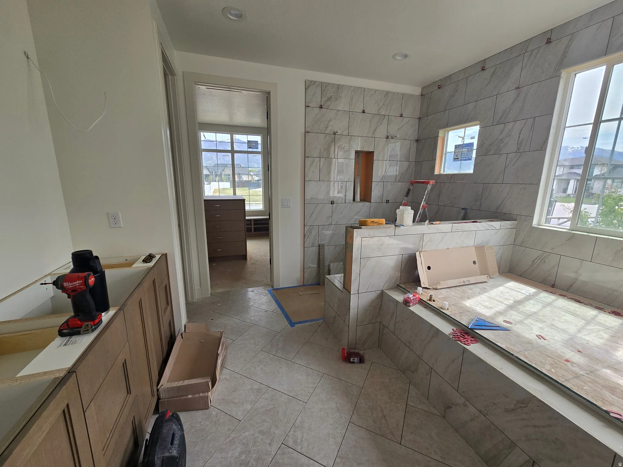 Bathroom featuring vanity, a garden tub, and light tile patterned flooring
