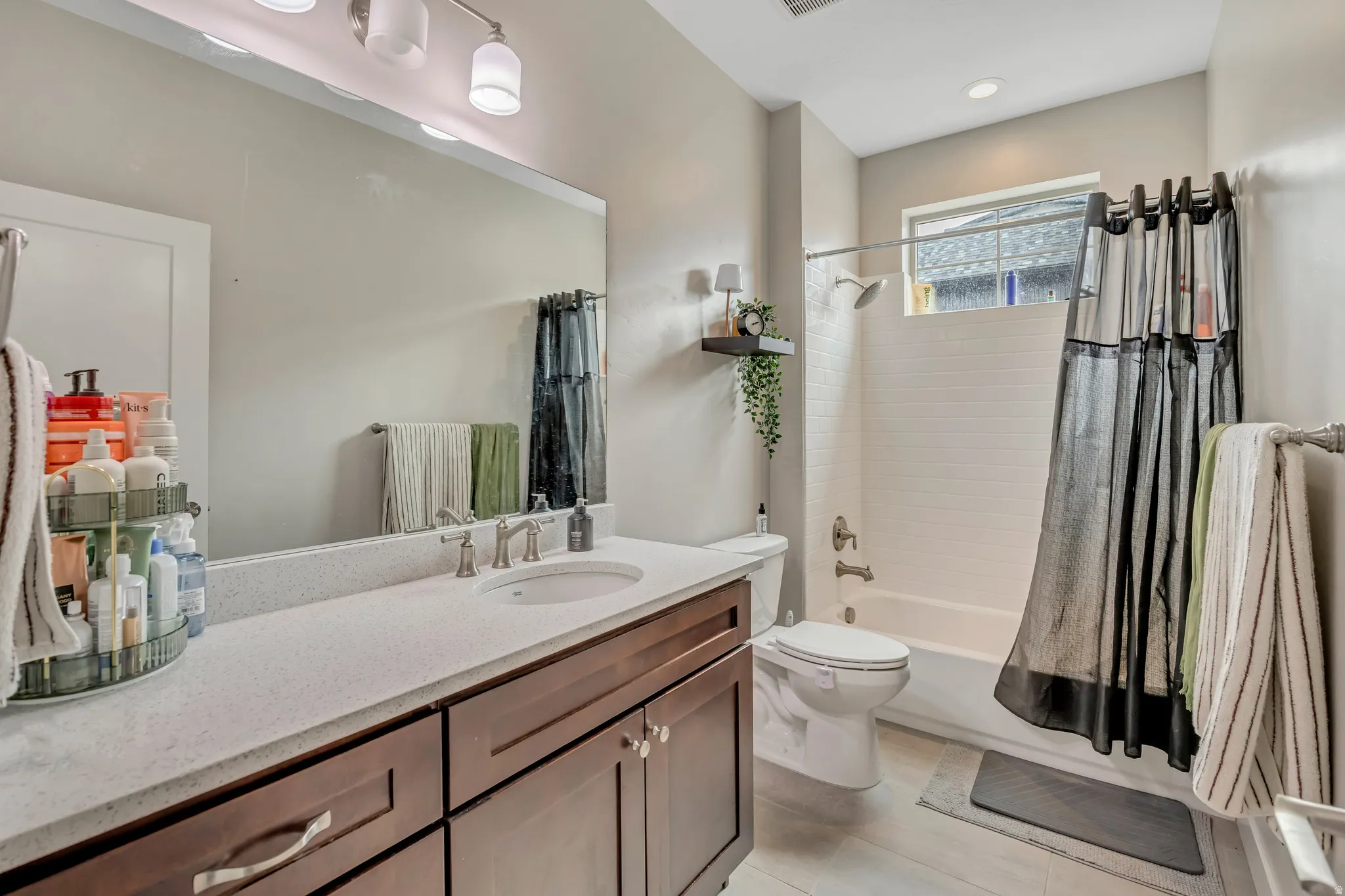 Bathroom with shower / bath combination with curtain and vanity