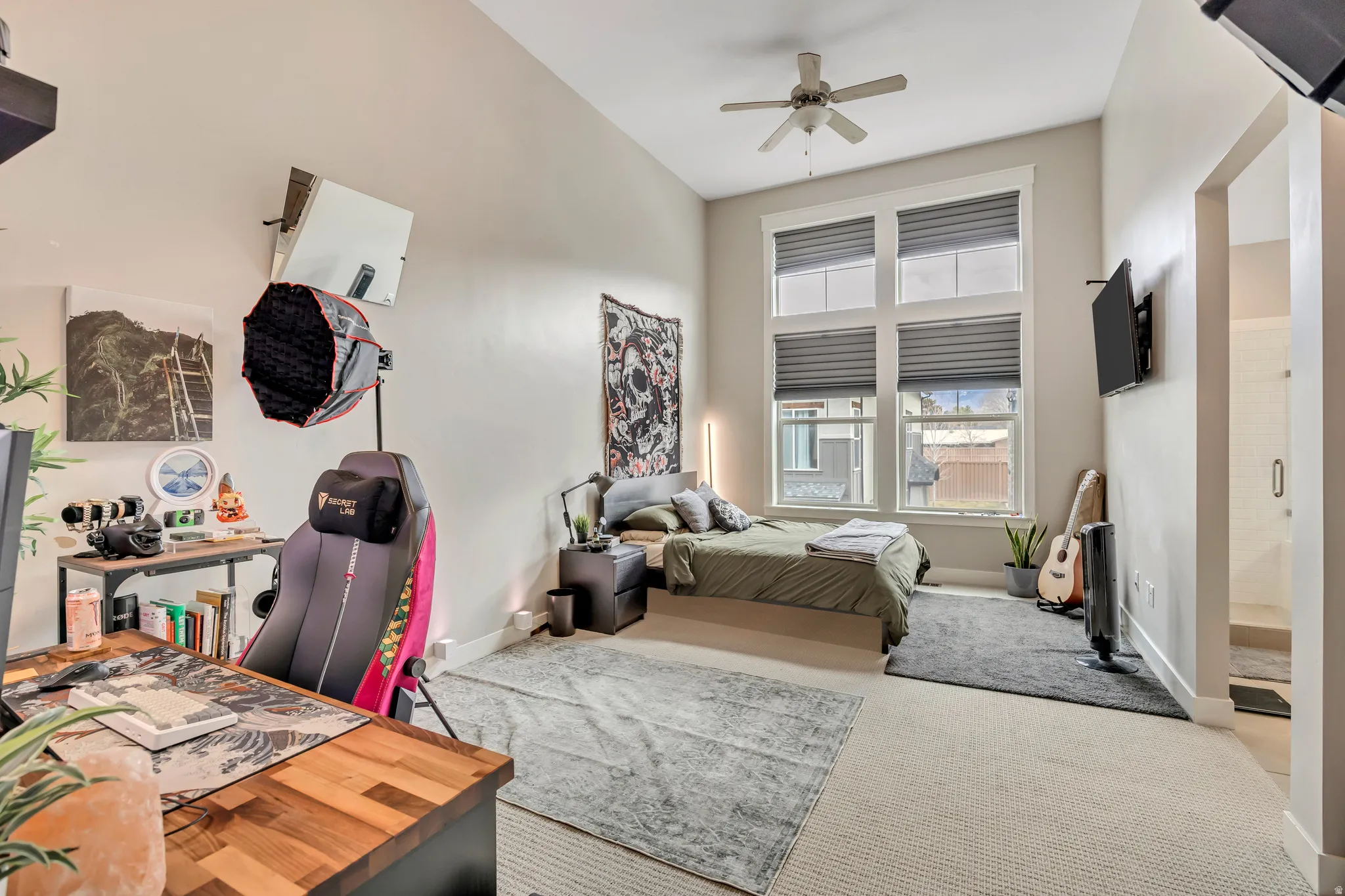 Bedroom with carpet floors, a ceiling fan, and ensuite bathroom