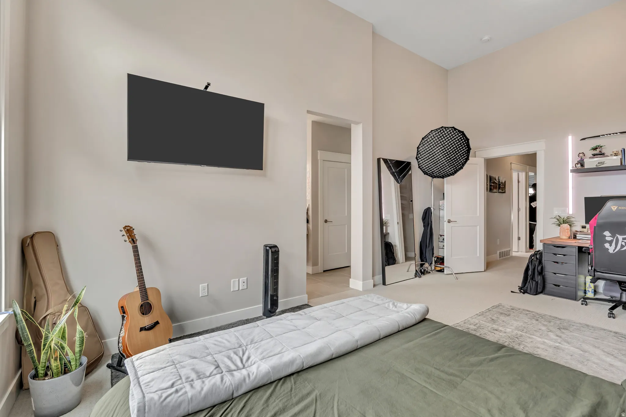 Bedroom featuring a desk, carpet, and a high ceiling
