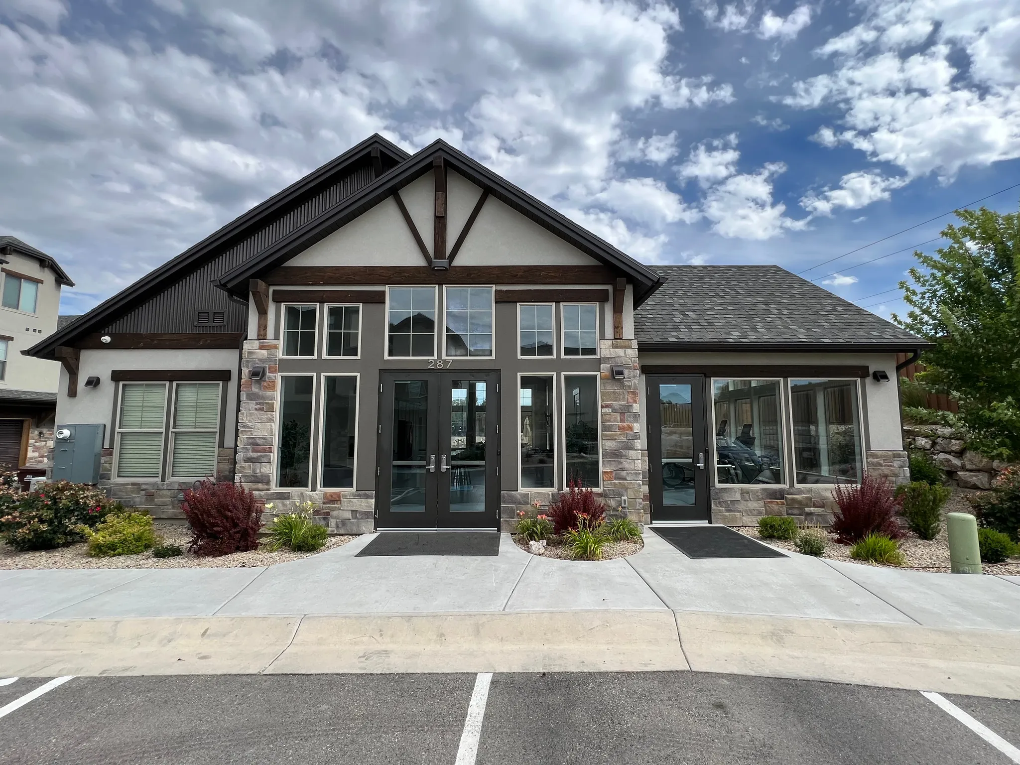 Entrance to property with stone siding, french doors, and stucco siding