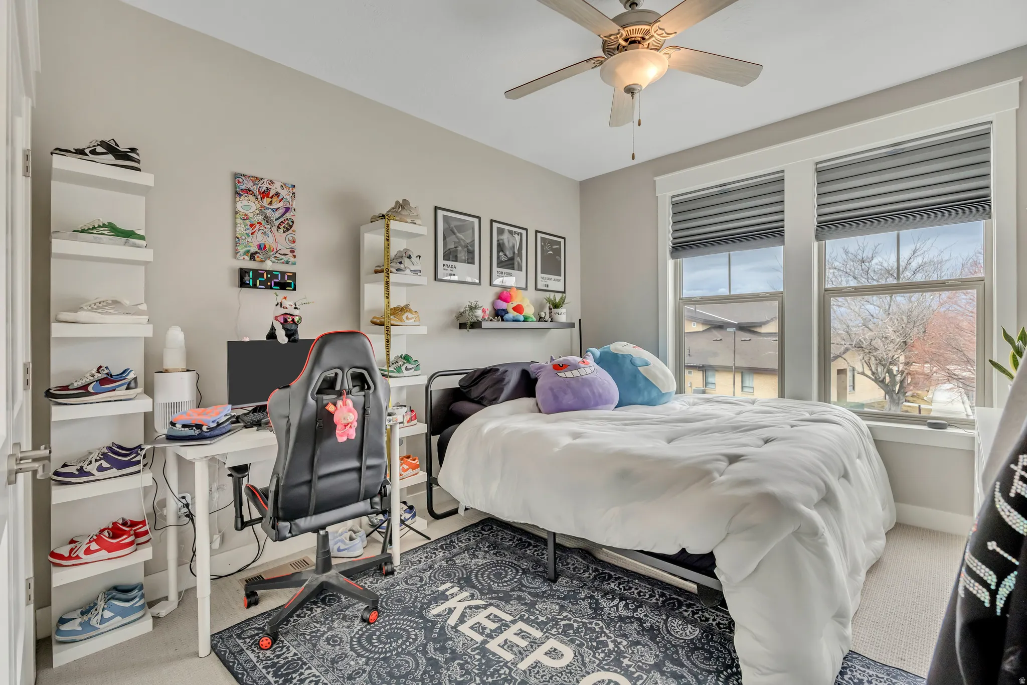 Carpeted bedroom featuring ceiling fan and an office area