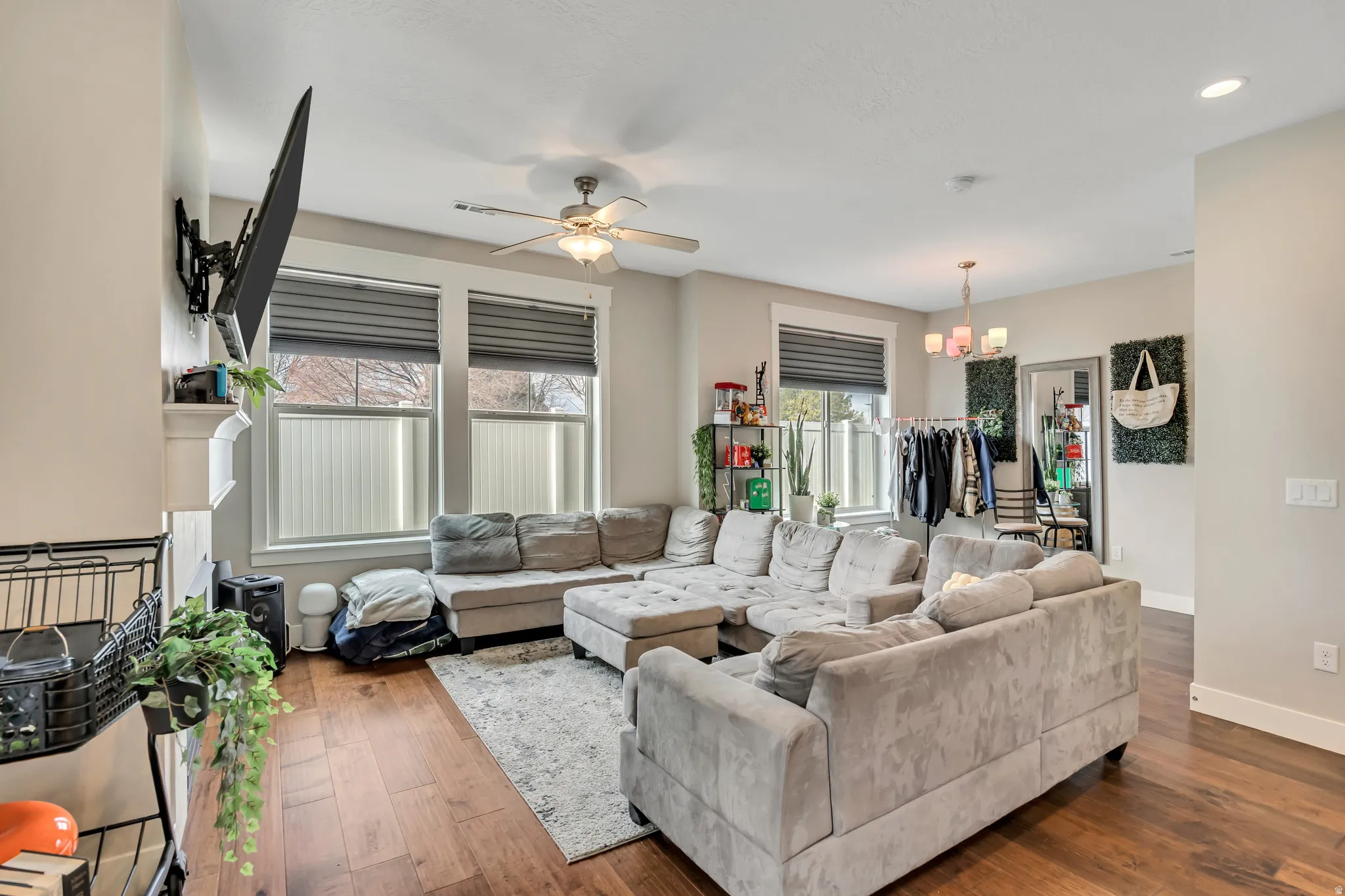 Living area featuring hardwood / wood-style floors, ceiling fan, hanging lights, and a fireplace