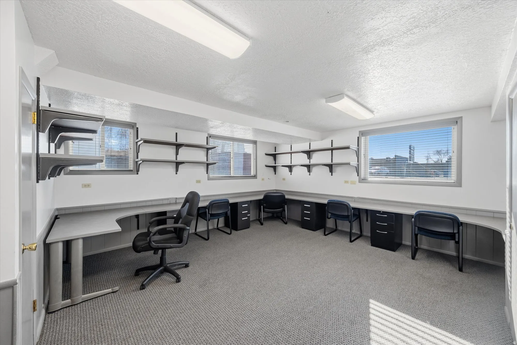 Office space with built in desk and a textured ceiling