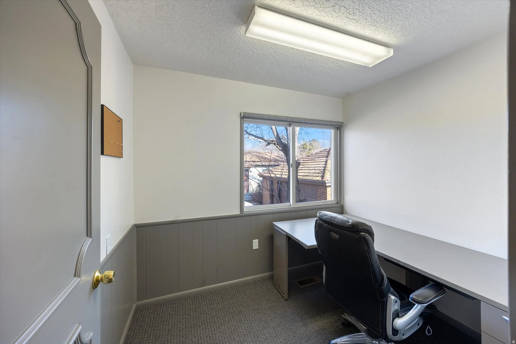Office with wainscoting, a textured ceiling, and carpet floors