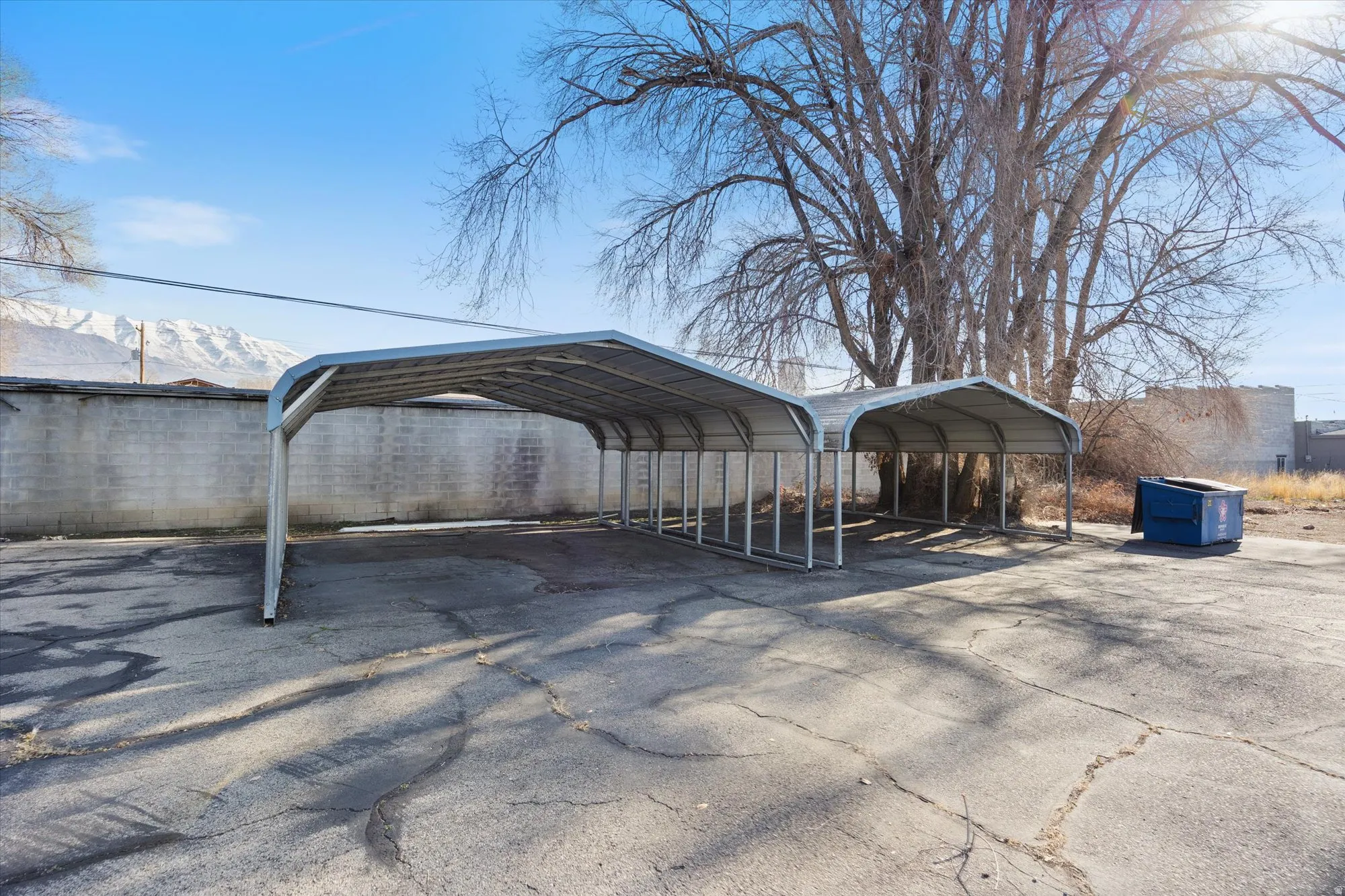 View of parking with a mountain view, a detached carport, and asphalt driveway