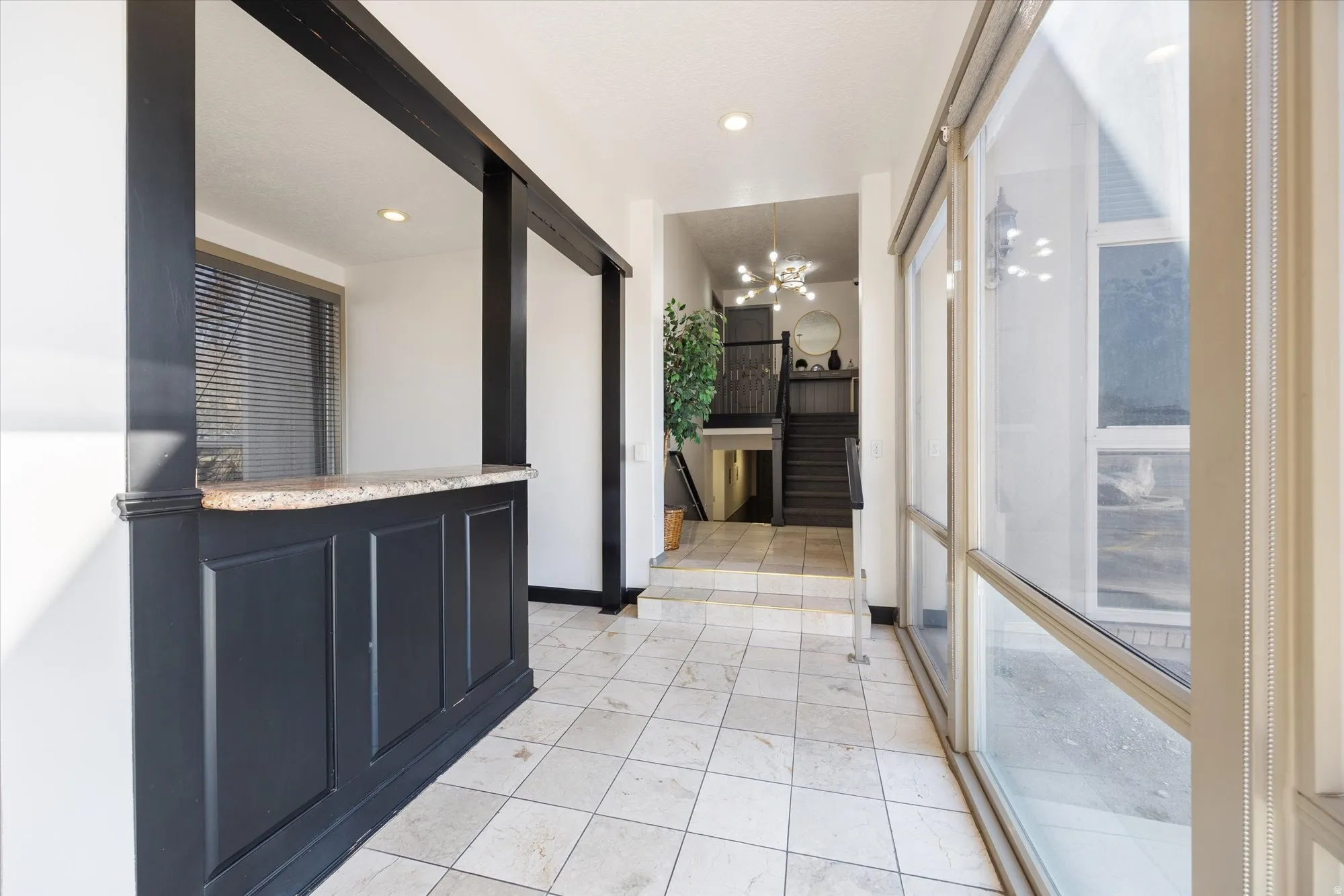 Hall featuring suspended lighting and baseboards