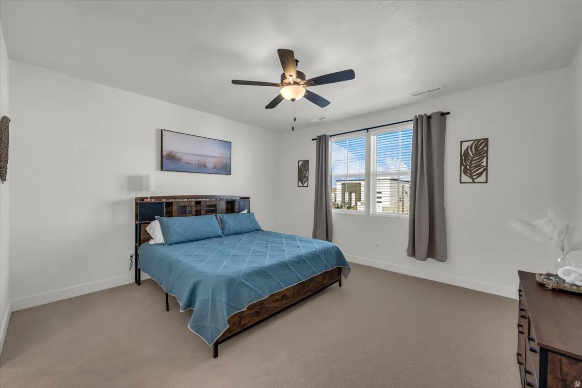 Bedroom with ceiling fan and carpet flooring