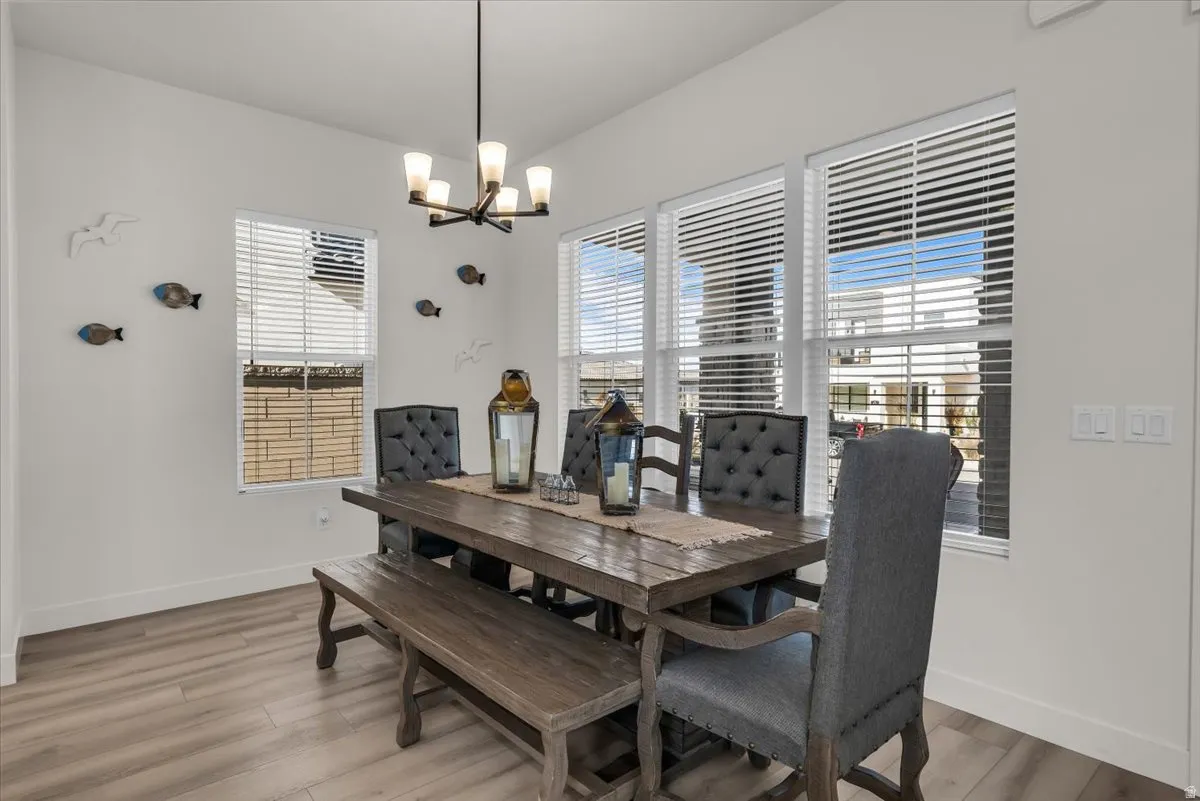 Dining room with light wood-type flooring and a chandelier