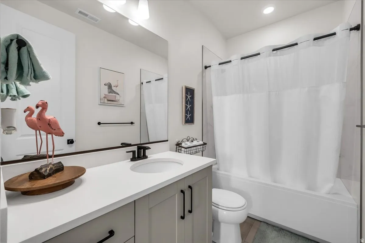 Bathroom featuring vanity and shower / bath combination with curtain