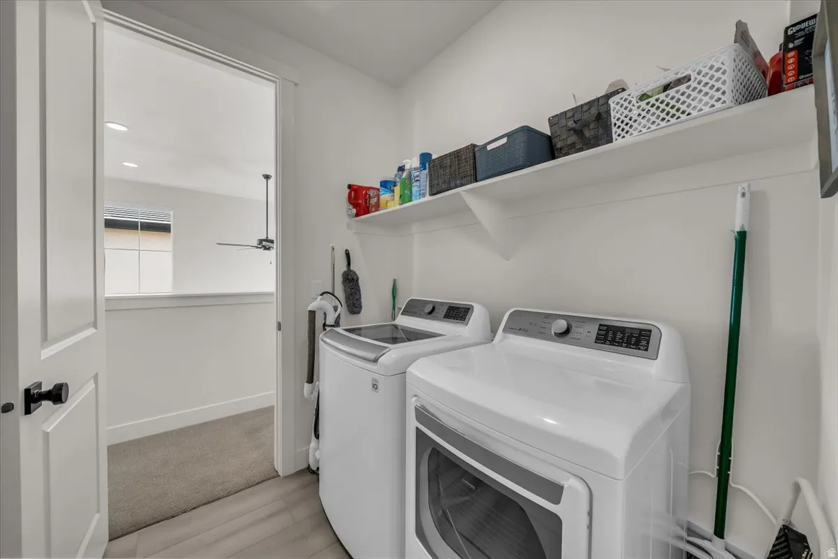Laundry room with washer and dryer, recessed lighting, and light wood-type flooring