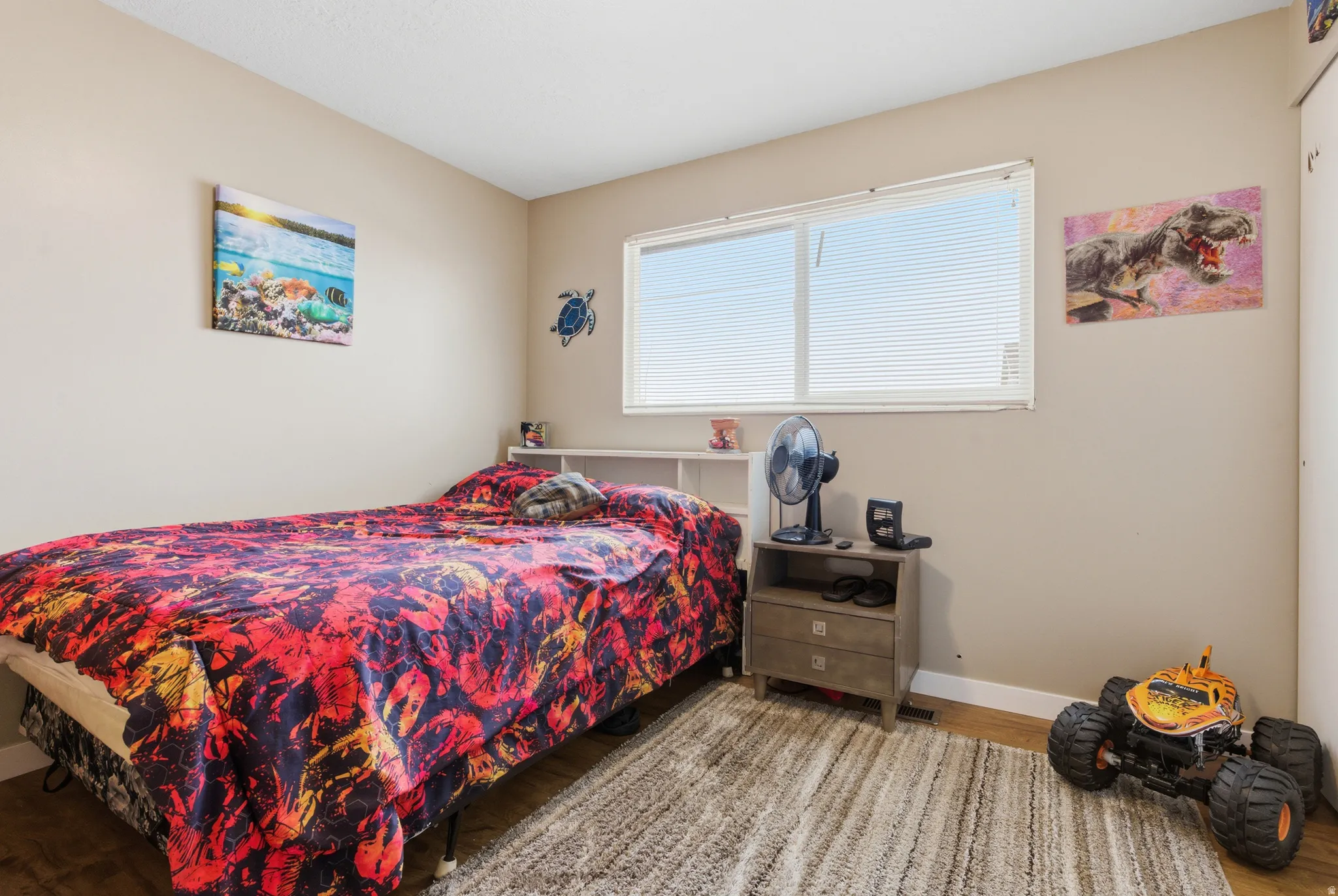 Bedroom with wood finished floors and baseboards