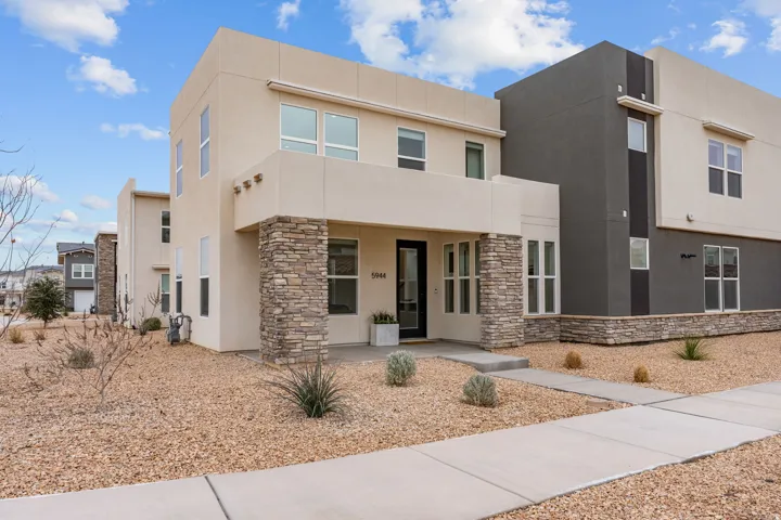 Contemporary home with stucco siding, stone siding, and a porch