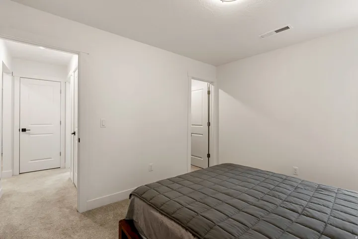 Bedroom featuring light colored carpet and baseboards