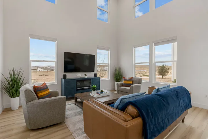 Living room with light wood-style flooring and a high ceiling