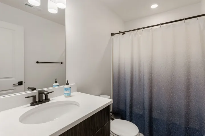 Bathroom featuring a shower with curtain and vanity