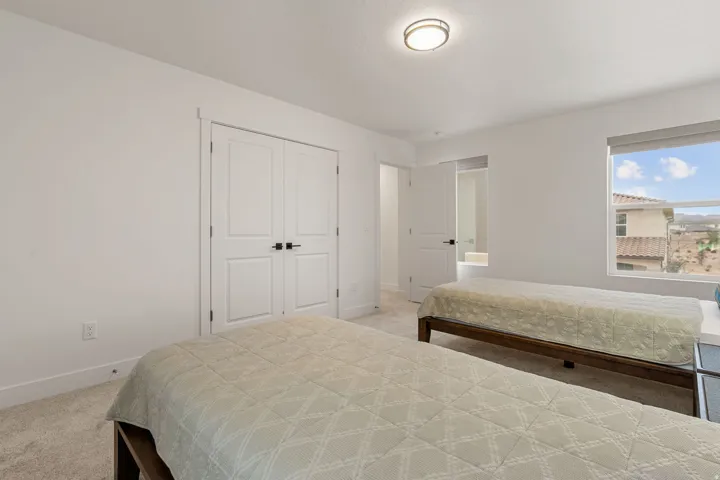 Bedroom featuring light colored carpet and a closet