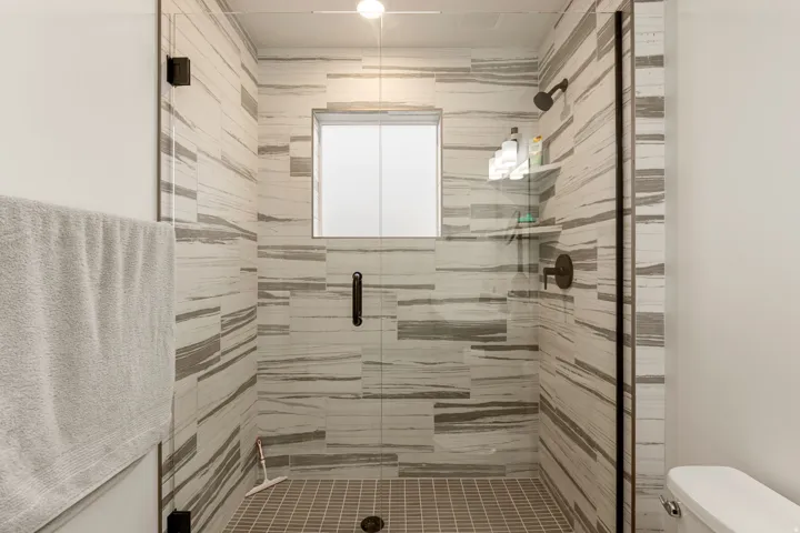 Bathroom featuring toilet and a stall shower