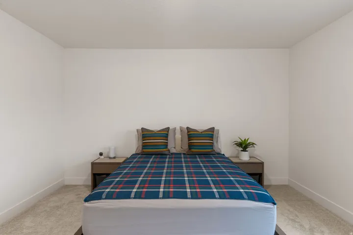 Bedroom with baseboards and light carpet