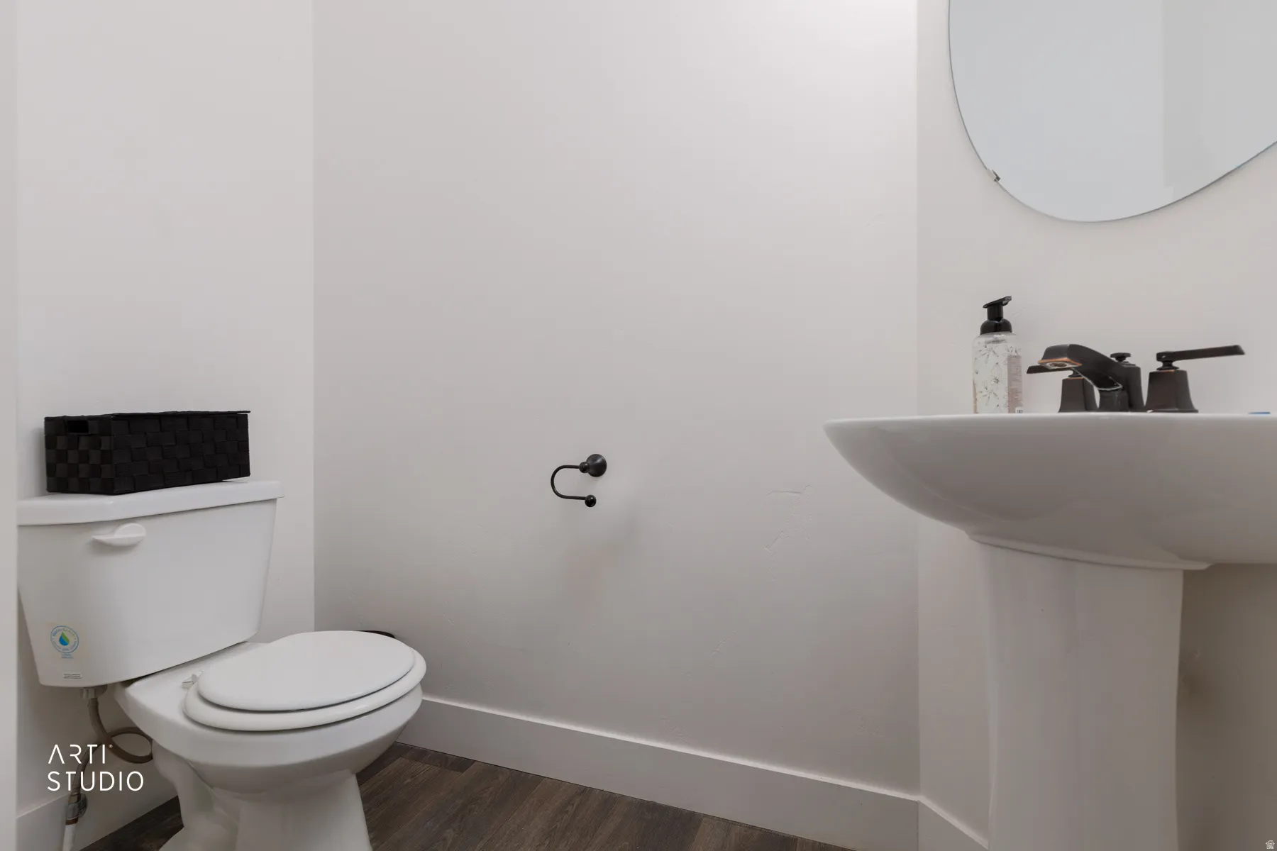 Half bath with wood finished floors and baseboards