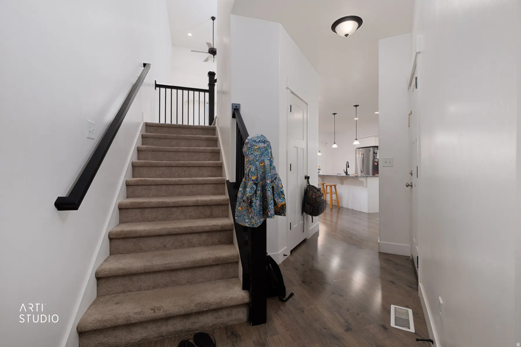 Staircase with wood finished floors, a ceiling fan, and recessed lighting