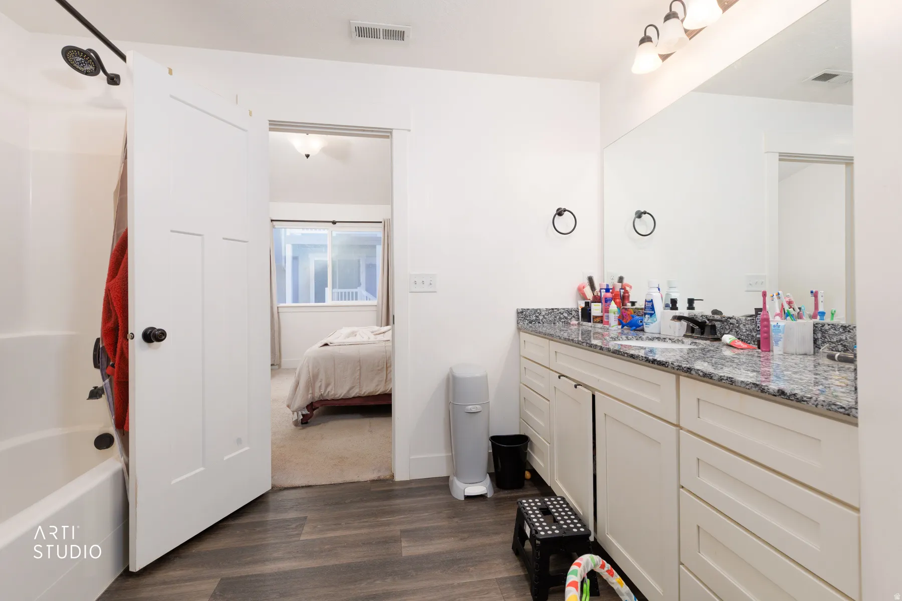 Ensuite bathroom with vanity, shower / washtub combination, and dark wood-style floors