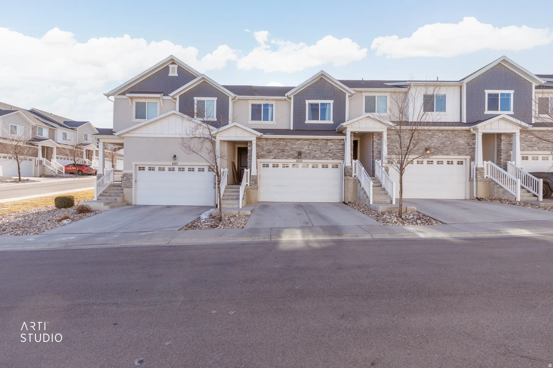 Craftsman-style home with stone siding, driveway, and a garage