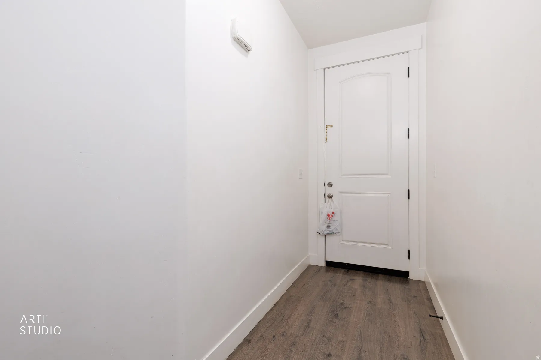 Doorway with baseboards and wood finished floors