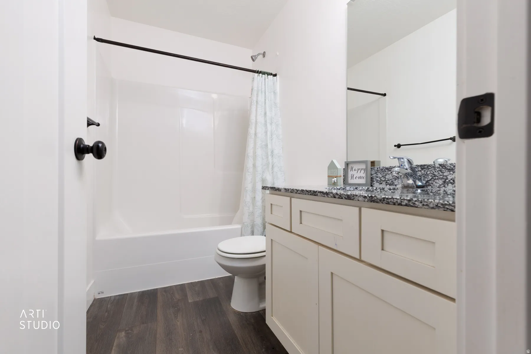Bathroom featuring vanity, shower / bathtub combination with curtain, and dark wood-style flooring