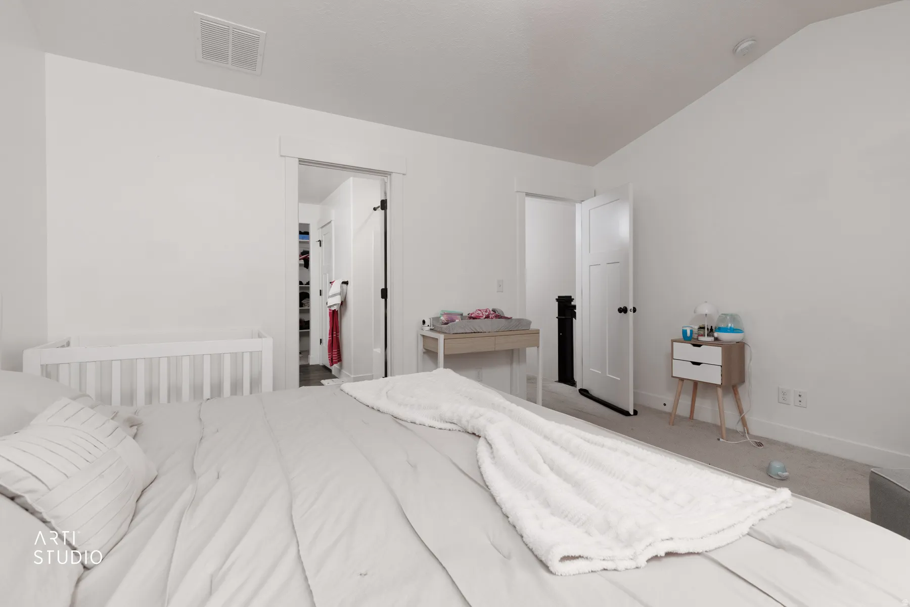 Carpeted bedroom featuring vaulted ceiling and a spacious closet